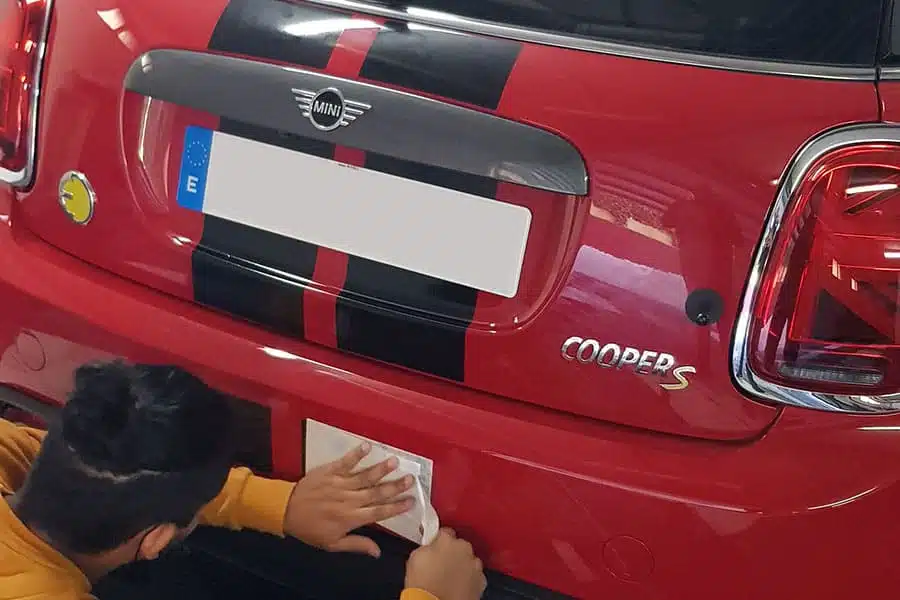 Hacer instalación de vinilo de corte en maletero de Mini Cooper rojo